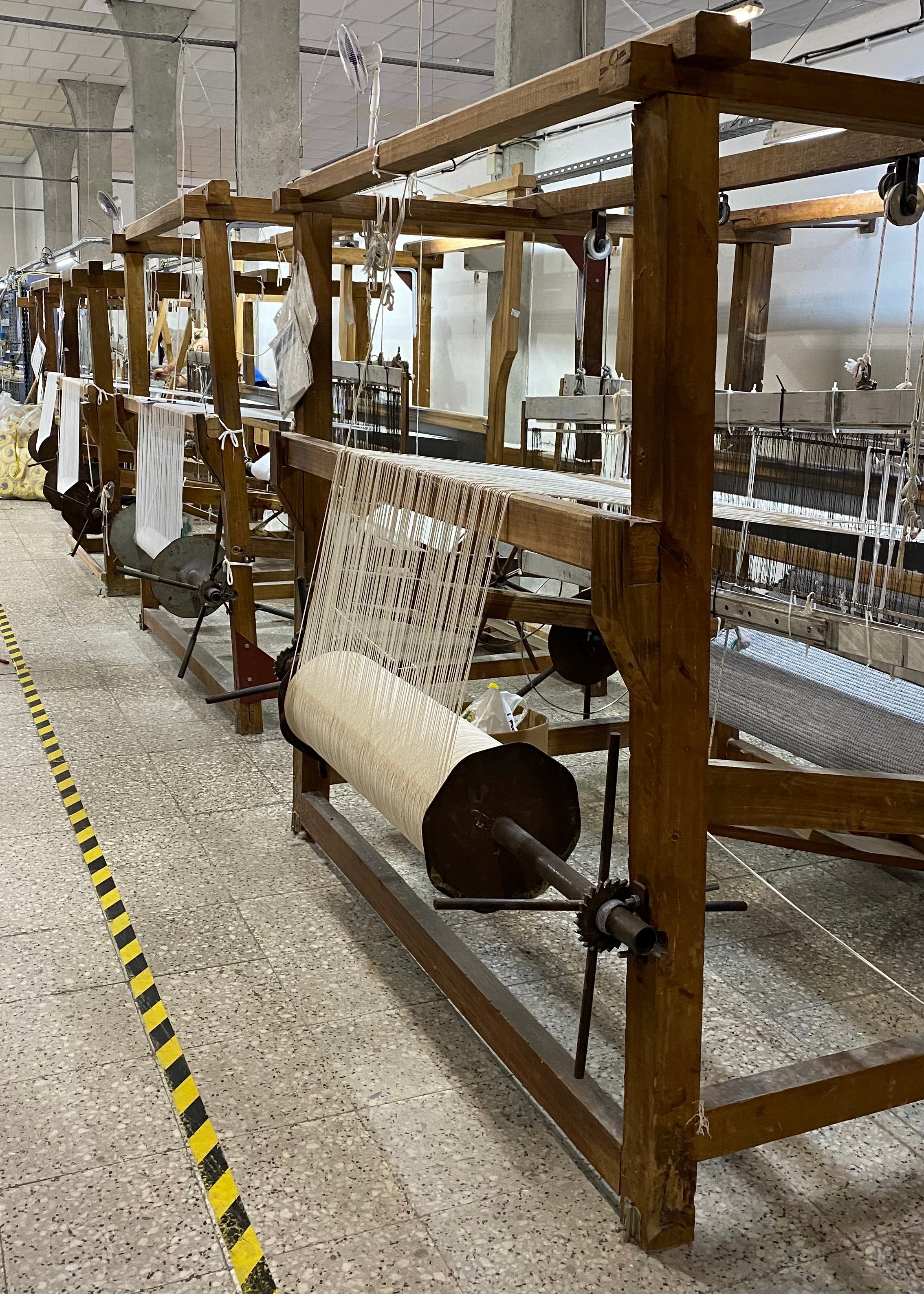 Large wooden weaving loom in a factory setting.